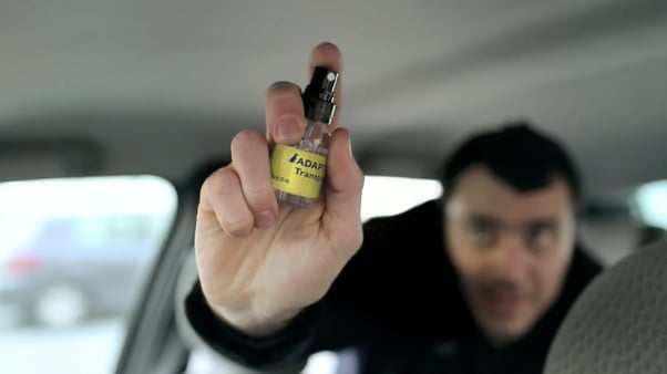 Man spraying ADAPTIL Transport in a car.