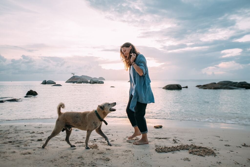Gazdi beszél a kutyájához a parton 