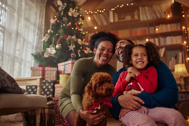 A family enjoying Christmas with their dog.